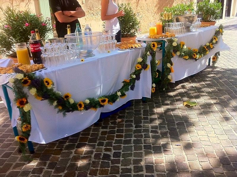 voici la décoration de la table buffet des rafraîchissement en guirlande de fleurs sur du cyprès de la provence pour la sortie de l'église de Cassis