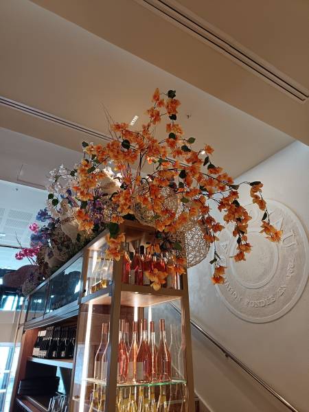 Le gros bouquet de bougainvillier en cascade est de la même couleur que les vins rosés de la vinothèque, un hasard, non ! Tout est calculé en amont pour que le décor floral soit en harmonie des produits et du concept du restaurant.
