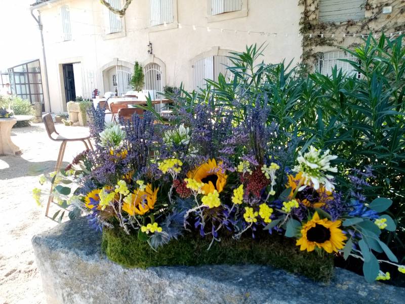 Les compositions florales sont posées tout autour de l'espace de réception du cocktail.