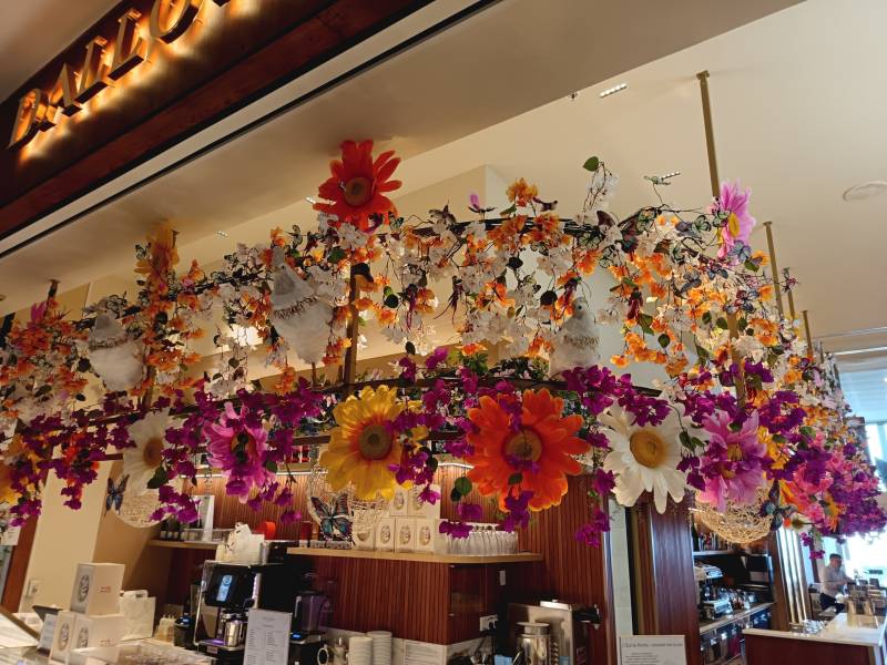 La frise florale suspendue est transparente pour alléger le décor afin de voir aussi les glycines du fond.