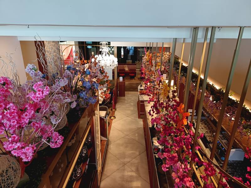 Le haut de la vinothèque du restaurant Dalloyau à Marseille est décorer de cerisier rose, d'iris bleu et de bougainvilliers orange. 