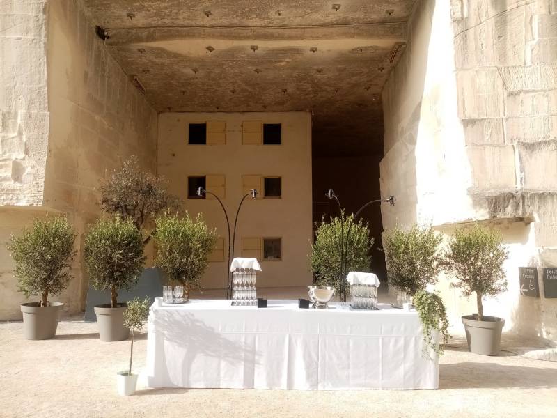 La table traiteur est entourée d'oliviers en rideau avec un passage pour  la circulation du service. 