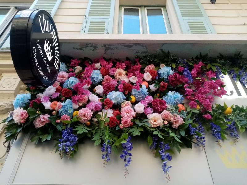 L'enseigne ronde ressort et est valorisée dans cet écrin de fleurs