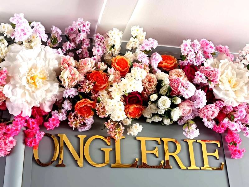 Des touches d'oranger dans les pivoines et des couleurs prunes procurent de l'énergie à l'ensemble très pâle. Le côté solaire au centre du décor rappelle l'or des lettrages.