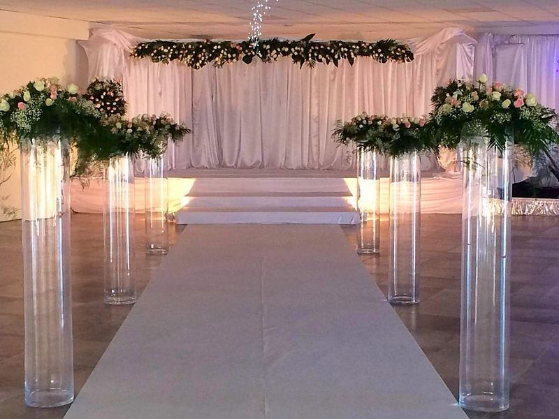 Les vases tubes en verre transparents donnent de la hauteur et accentue la perspective de l'allée.