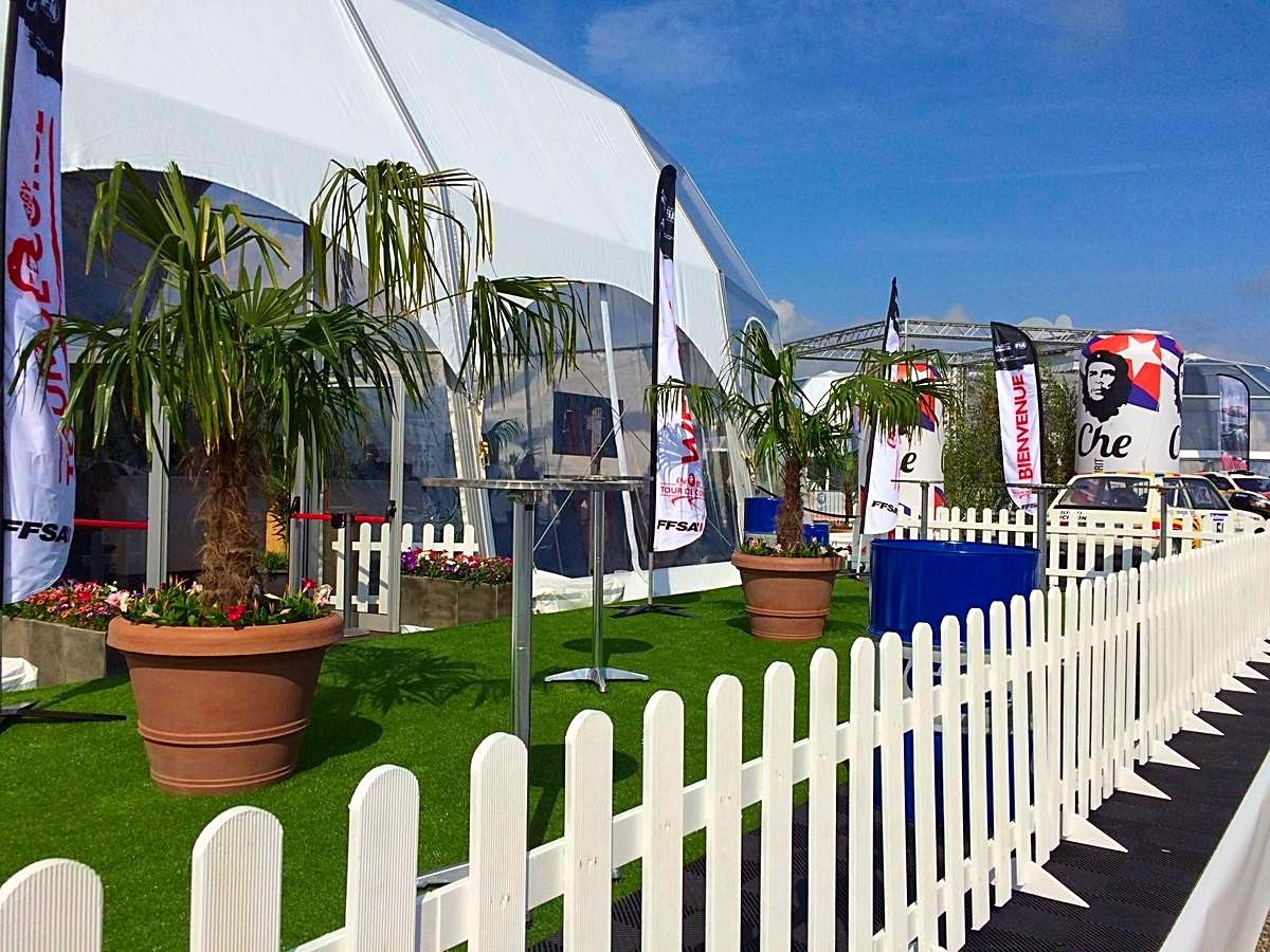 Les palmiers trachycarpus fortunei en gros pot fleuris de dipladenia décore les espaces de détente sur terrasse extérieure.
