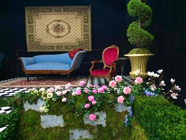 Faux mur de pierre recouvert de rosiers en fleurs.