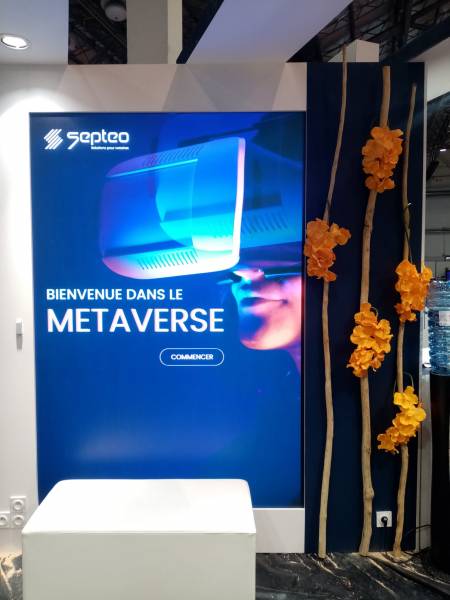 La couleur orange des orchidées contrastent avec le fond bleu et l'affiche du stand.