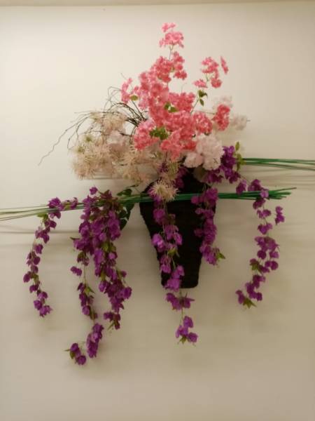 Des compositions florales murales de fleurs artificielles ornent les murs du restaurant Dalloyau Paris.