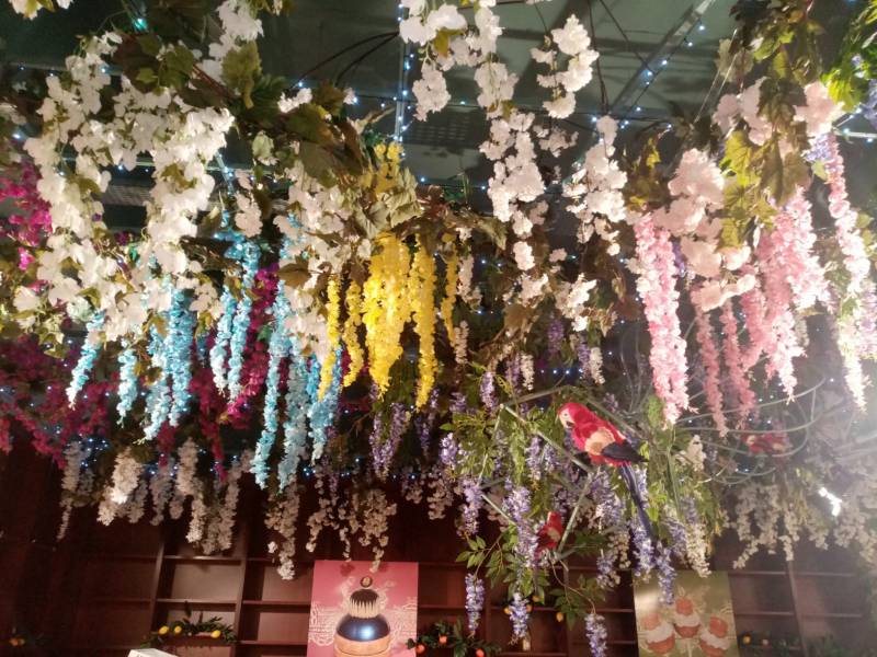 Les couleurs des fleurs sont en harmonie avec les affiches des mets que le restaurant Dalloyau propose à sa clientèle.