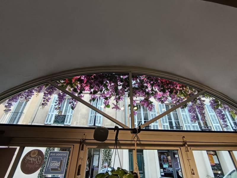 Les fleurs en cascade ornent par transparence l'intérieur du restaurant de ce restaurant d'Aix en Provence.