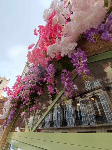 La décoration florale suit avec grace l'arche en voute de la vitrine de ce restaurant aixois.
