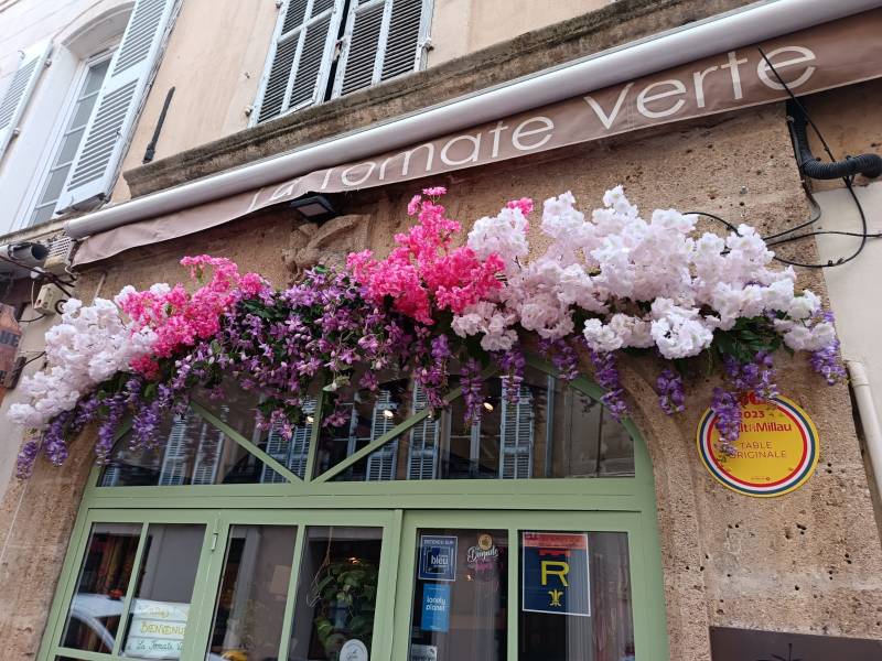 Le style floral de cette décoration florale de vitrine en fleurs artificielles de qualité est symétrique par rapport à la vitrine en fer forgé.